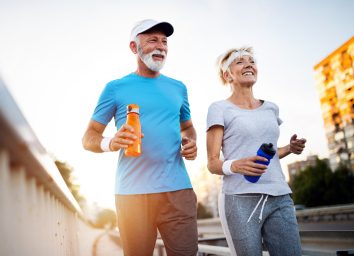 older active couple running outside