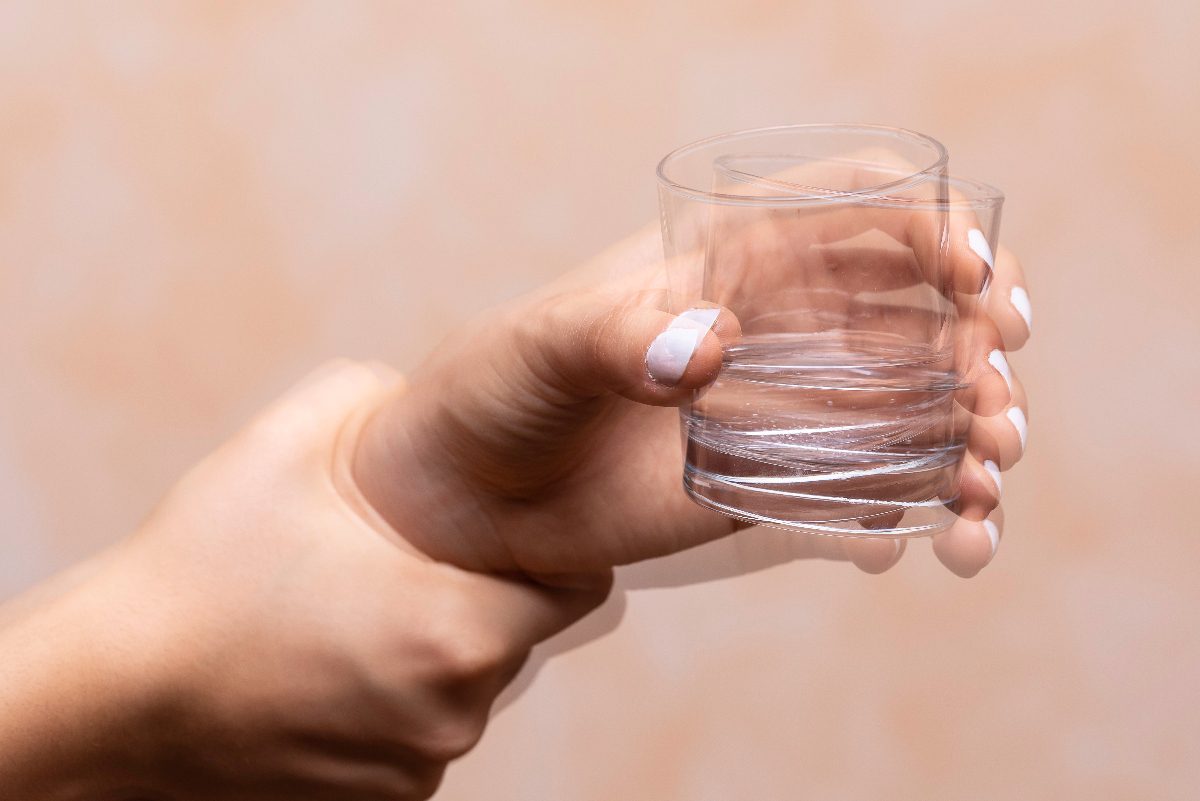 Parkinson's disease woman holding glass