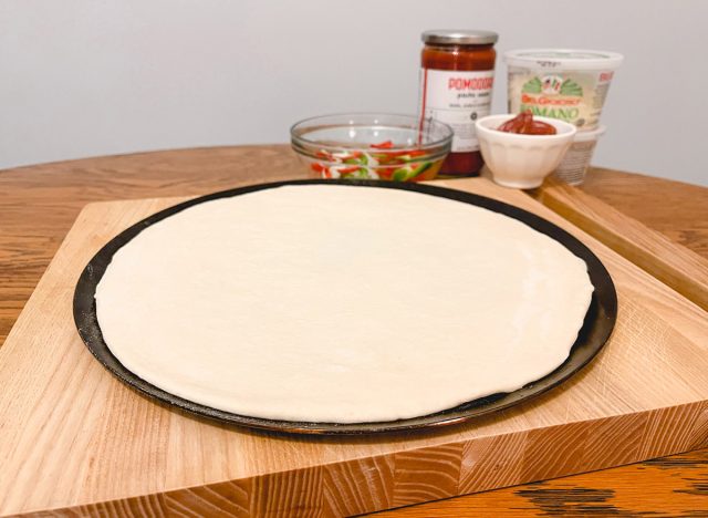Coloque la masa en la bandeja para pizza sólida antes de preparar la pizza.