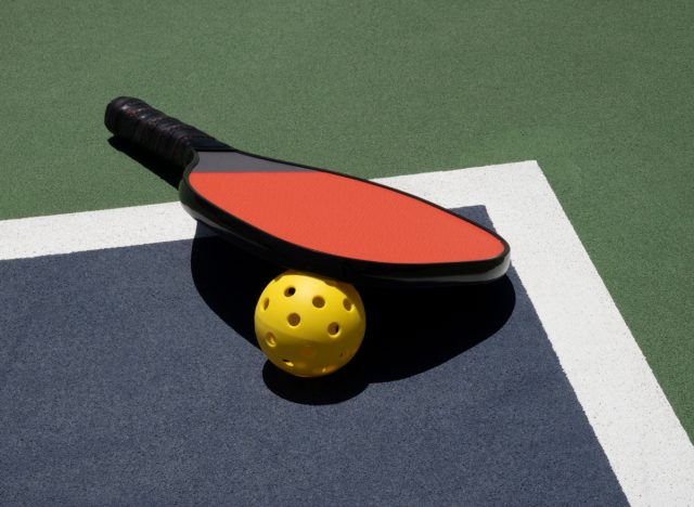pickleball paddle and ball on court