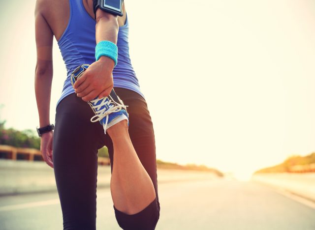 runner warms up and stretches before a run, sunny day