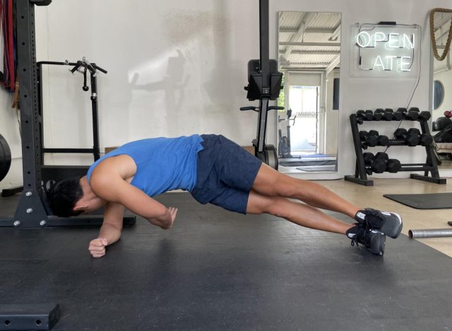 trainer doing the side plank rotation