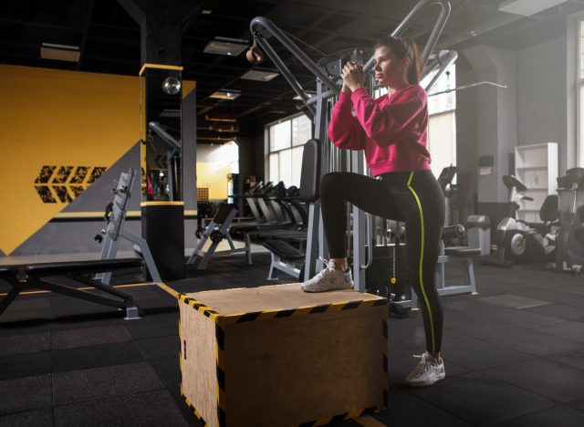 woman doing step-up exercise in gym to strengthen weak knees