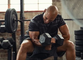 man in 40s using dumbbells to jumpstart weight loss goals