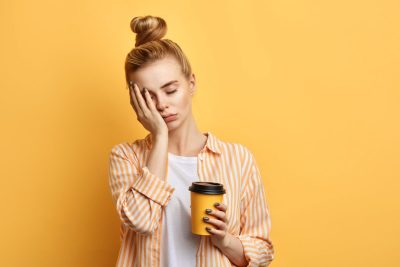 tired woman holding coffee