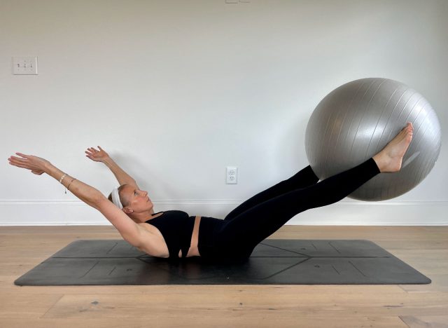 trainer demonstrating v-pass stability ball exercise to shrink belly fat