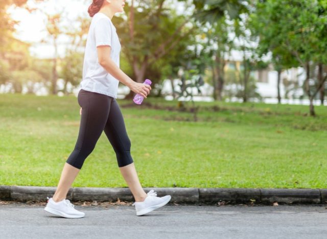 woman walking, performing physical activity to lower risk of heart disease