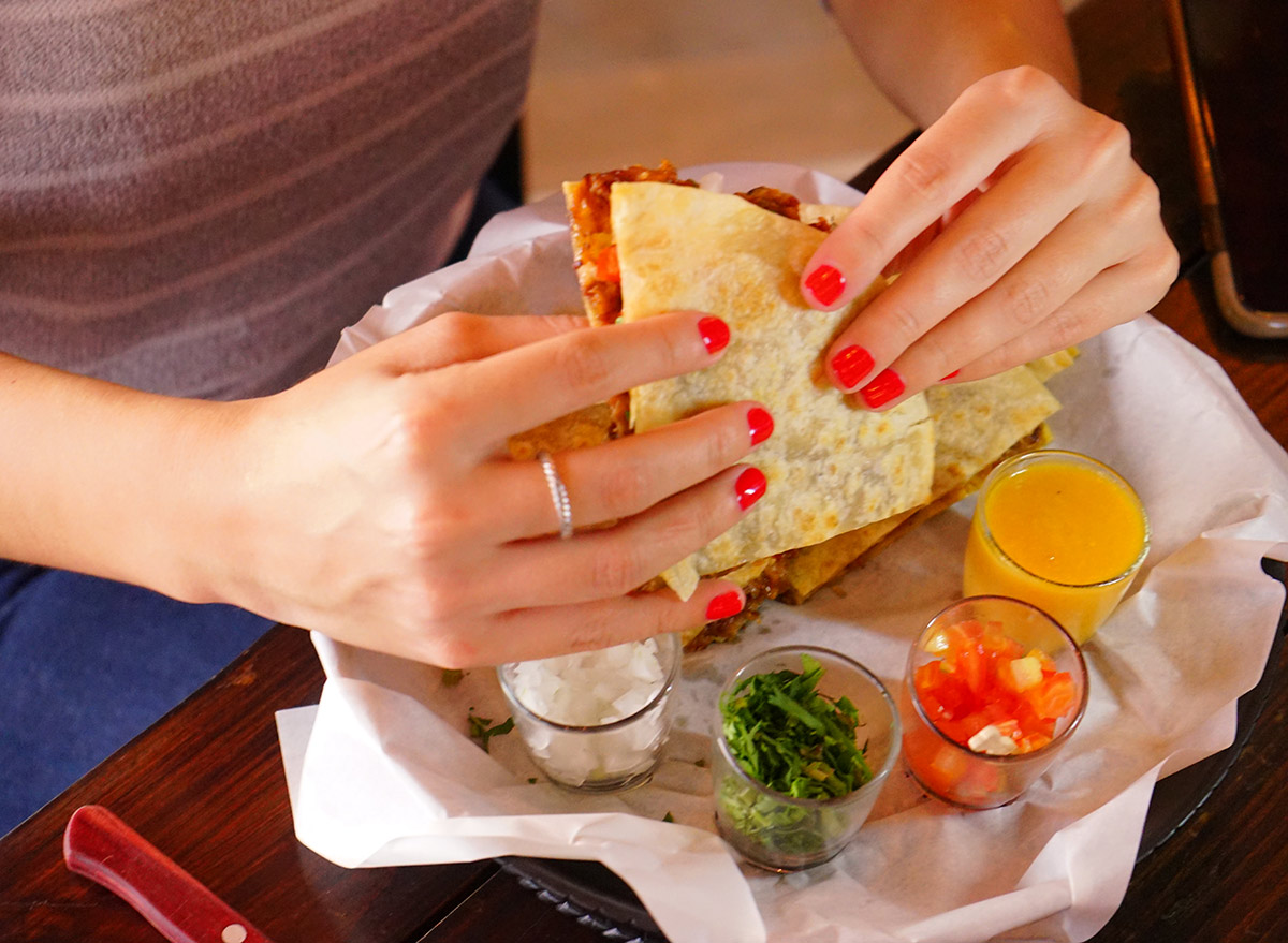 woman eating quesadilla