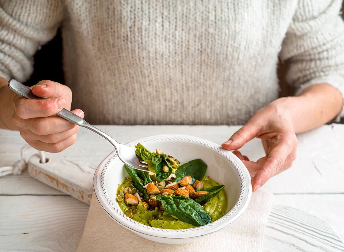 woman eating spinach lunch bowl