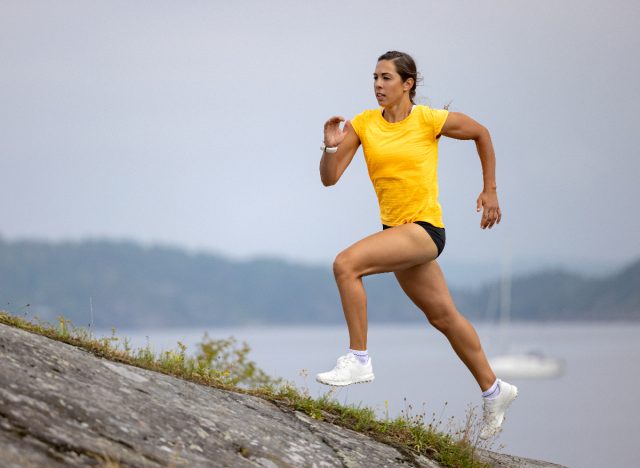 mujer atlética corriendo cuesta arriba