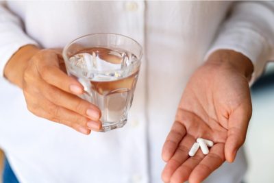 woman holding white pills