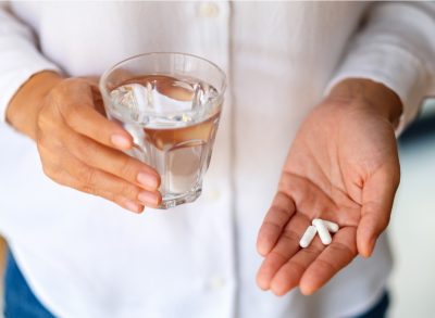 woman holding white pills