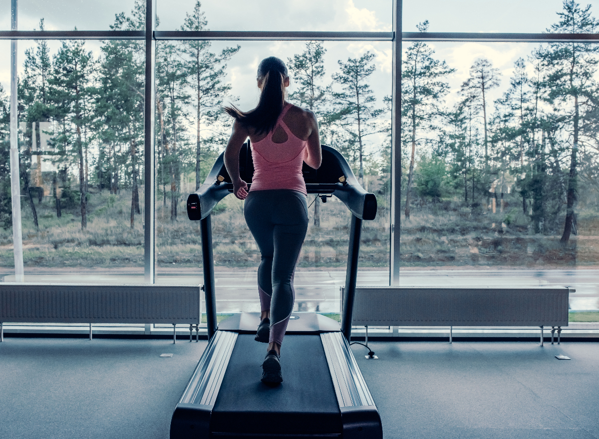 woman doing scenic treadmill workout in front of large windows