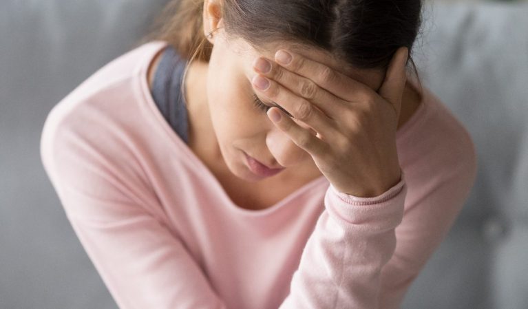 woman dealing with severe headache or migraine at home