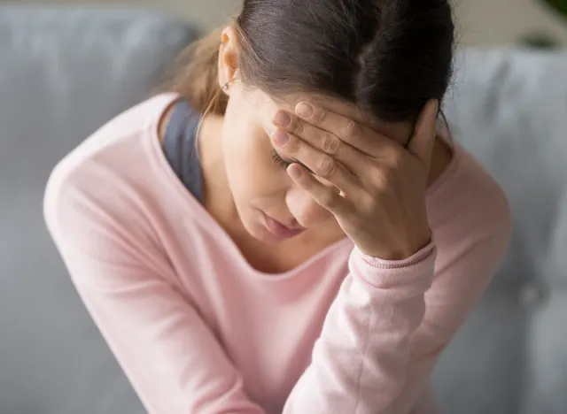 kvinde, der lider af svær hovedpine eller migræne i hjemmet