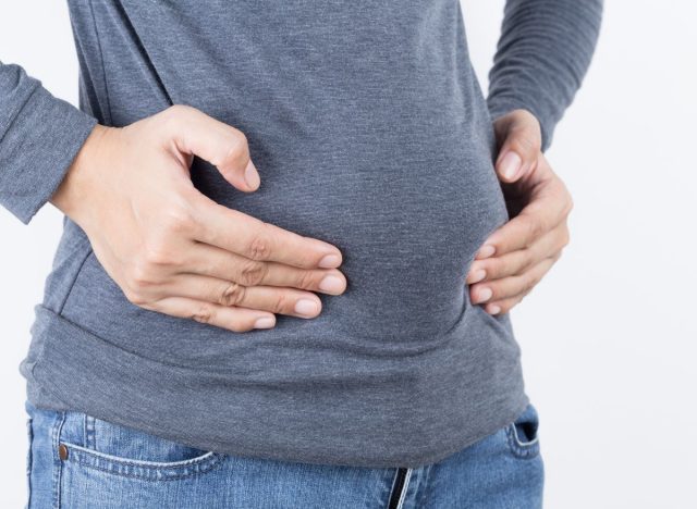 Woman holding bloated belly