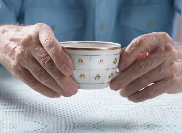 Older hands holding tea cup