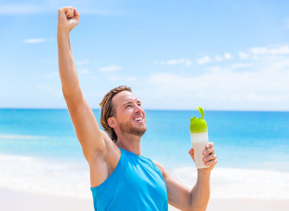 Man pumping fist in air with drink