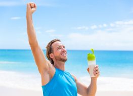Man pumping fist in air with drink