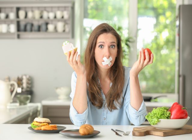 Woman with taped mouth, can't eat food