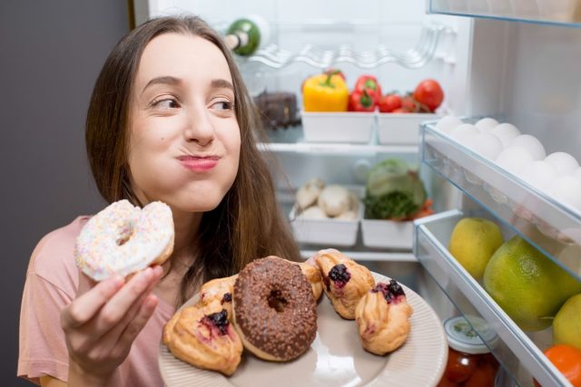 Woman eats sugary junk food