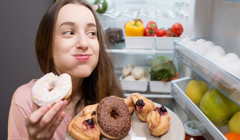 Woman eating sugary junk food