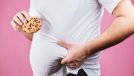 Man holding stomach with cookie