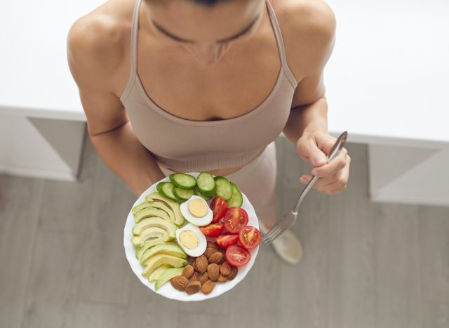 athletic woman smart snacking after workout, almonds and veggies