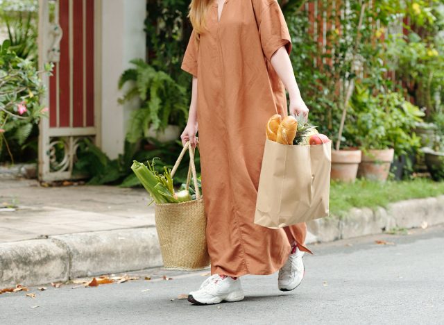 mujer que lleva bolsas de supermercado del auto a la casa, pierde peso sin 