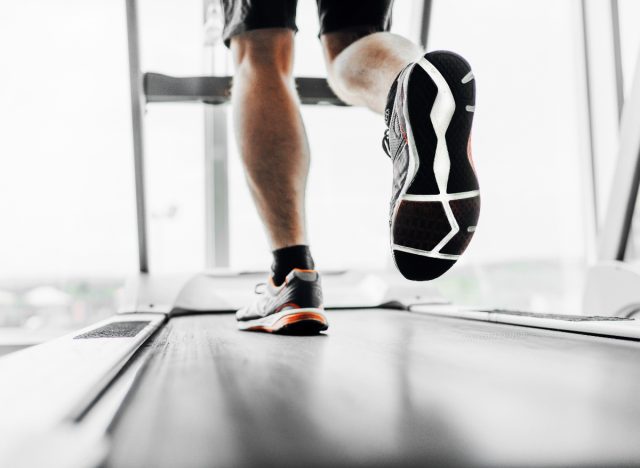 closeup feet treadmill run, man doing cardio workout