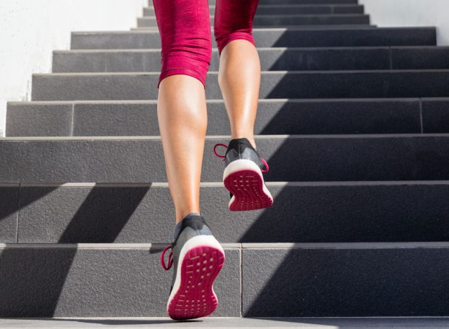 Primer plano de los pies de la mujer, zapatillas rosas calientes subiendo escalones, haciendo ejercicio