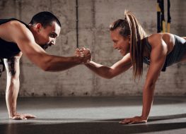fit couple doing couples workout in gym
