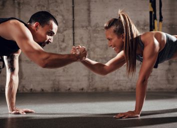 fit couple doing couples workout in gym