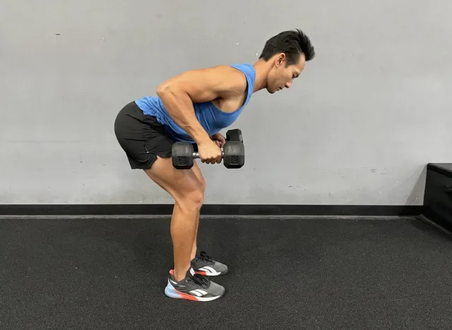 trainer demonstrating dumbbell bent over row to burn fat in your midsection