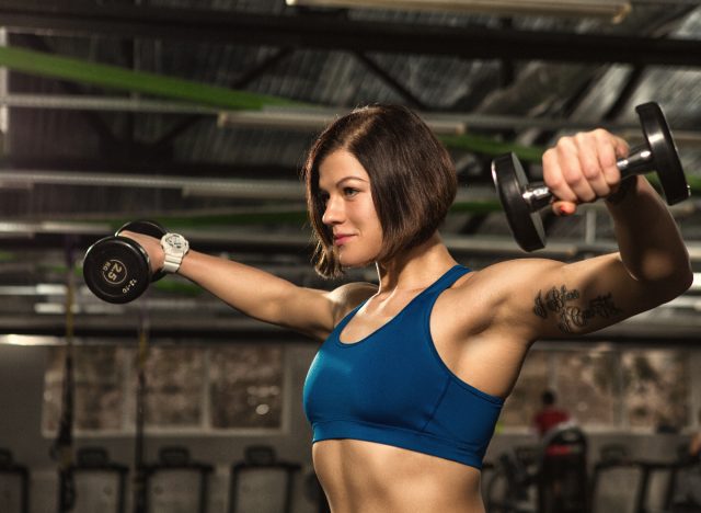 woman demonstrates dumbbell lateral raise exercises to regain muscle mass in your arms