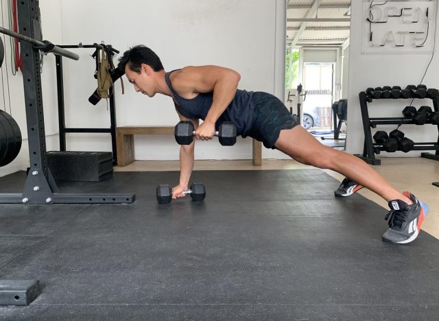 trainer doing dumbbell renegade row, demonstrating how to get rid of a pot belly