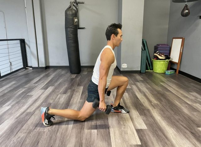 The trainer demonstrates a dumbbell squat split to move metabolism after 40