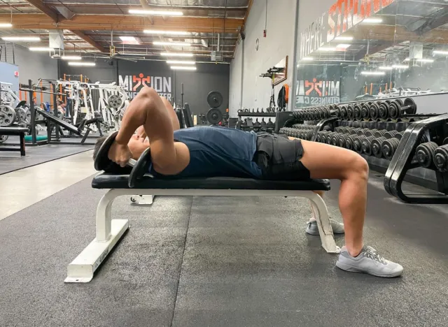 trainer performing dumbbell triceps extension