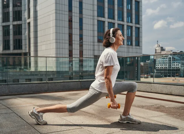 senior woman doing lunges with dumbbells as part of leg-strengthening exercises for seniors