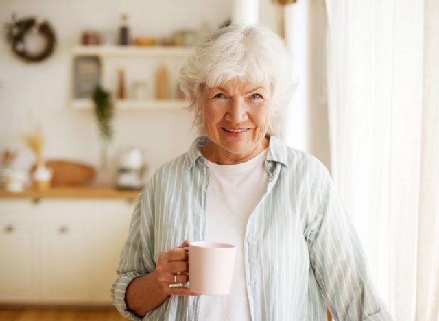 an older woman is drinking coffee