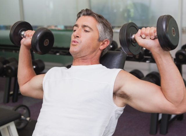 fit mature man doing dumbbells workout