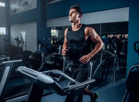 fit man doing fat-burning workout on treadmill in gym