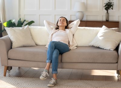 happy woman relaxing on couch in her clean home