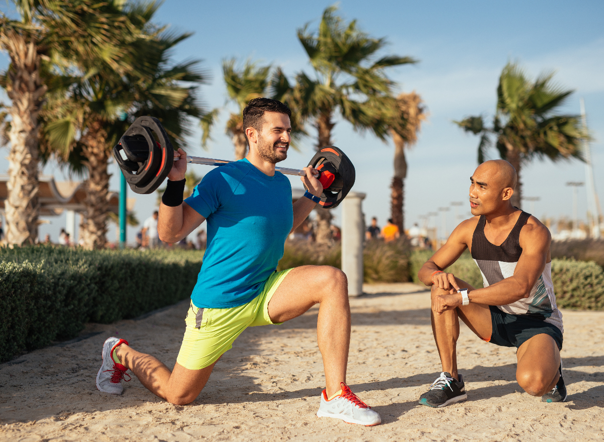 man performing barbell workout on the beach for weight loss