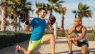 man performing barbell workout on the beach for weight loss