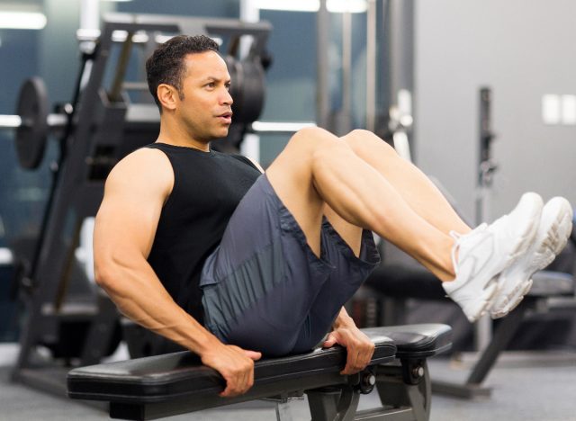 man in his 40s doing legs, core workout in gym