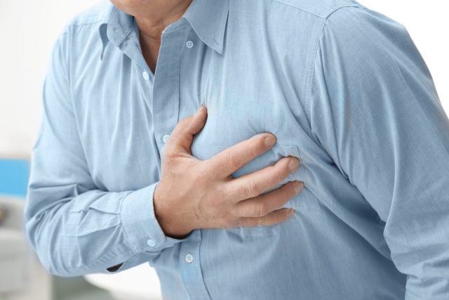 man dealing with chest pain, heart disease