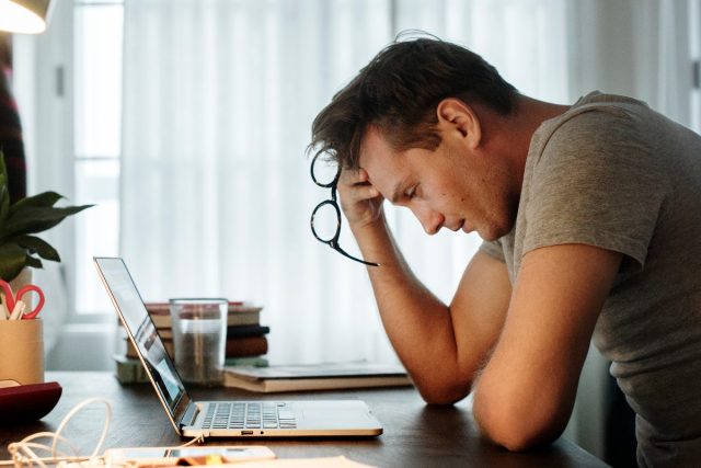 Mann mit hohem Stress bei der Arbeit, Panikattacke