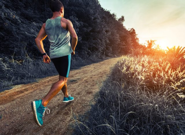 man jogging uphill at sunset to burn double the calories