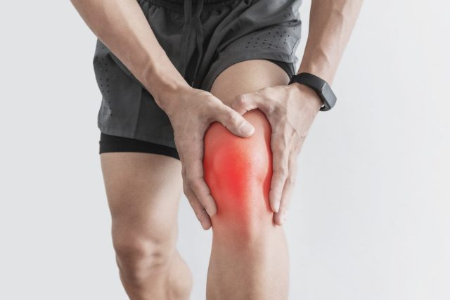 closeup man dealing with knee pain, arthritis